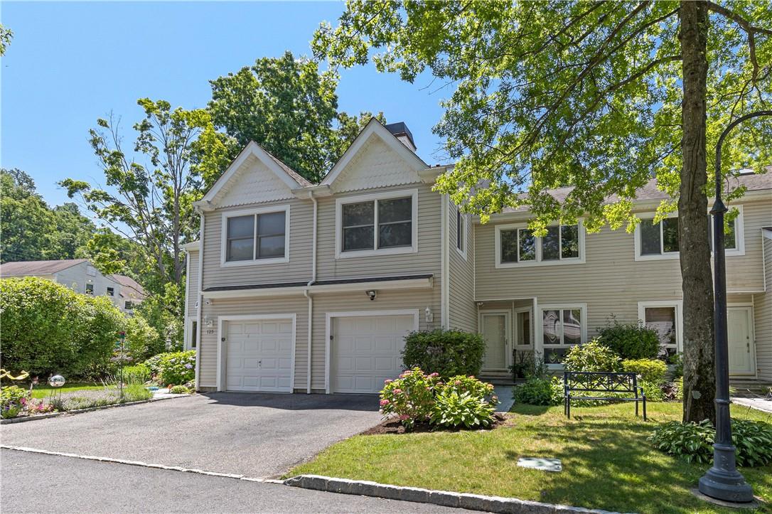View of front facade featuring garden area and 1 car garage