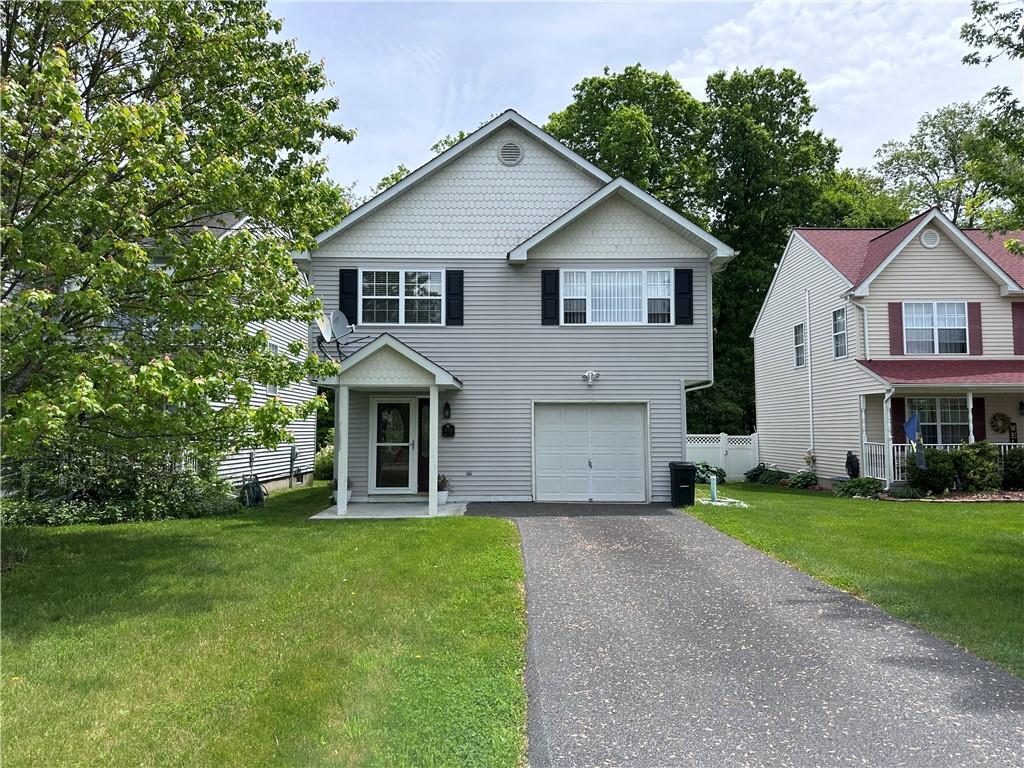 View of front of house featuring a front lawn and a garage