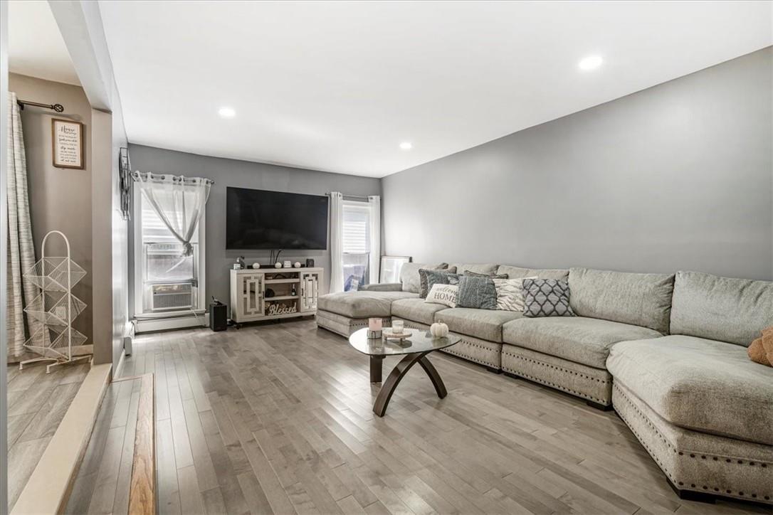 Sunken Living room with hardwood flooring and recessed lighting open to dining and kitchen area