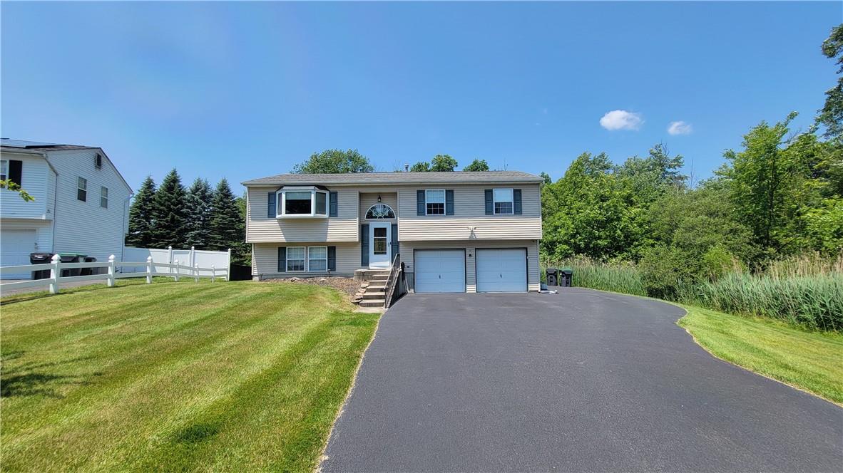 Bi-level home featuring a front yard and a garage