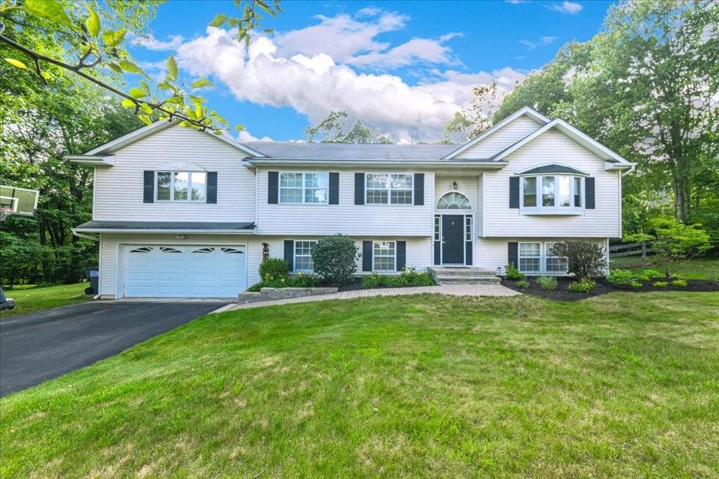 Split foyer home with a garage and a front lawn
