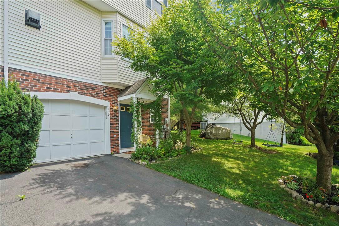 View of front of house with a garage and a front yard