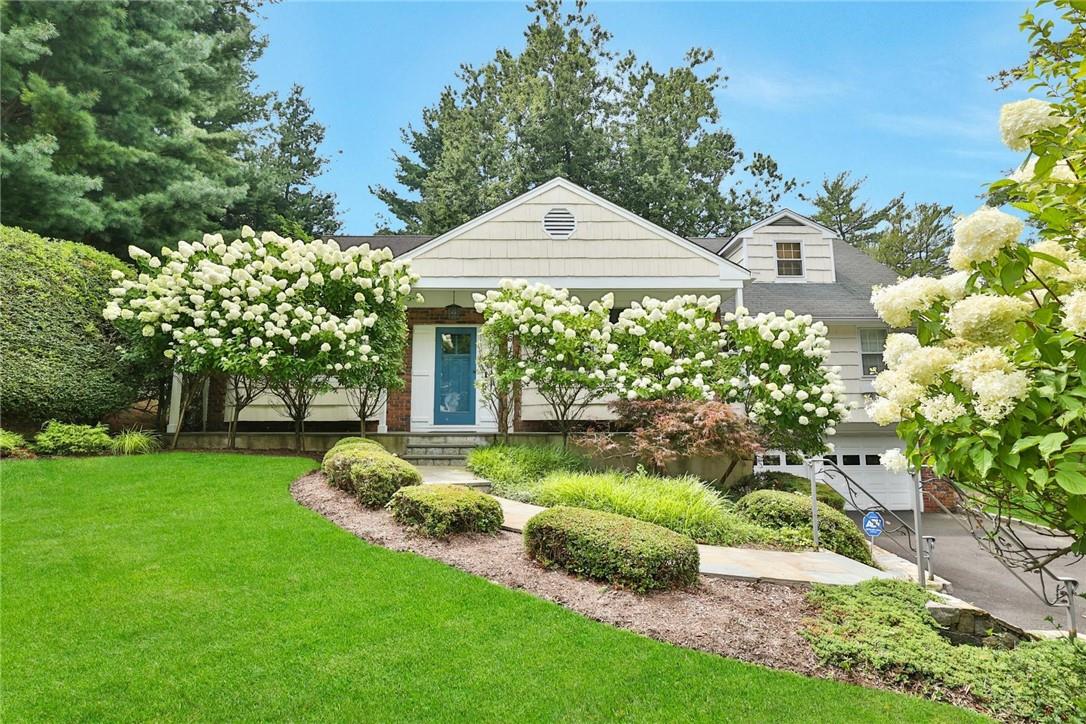 View of front of house featuring a garage and a front yard