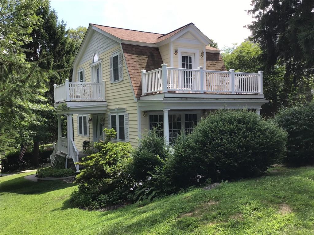 Front view.  Notice the gated entrance, stone walkway, covered front porch and two upper level decks.