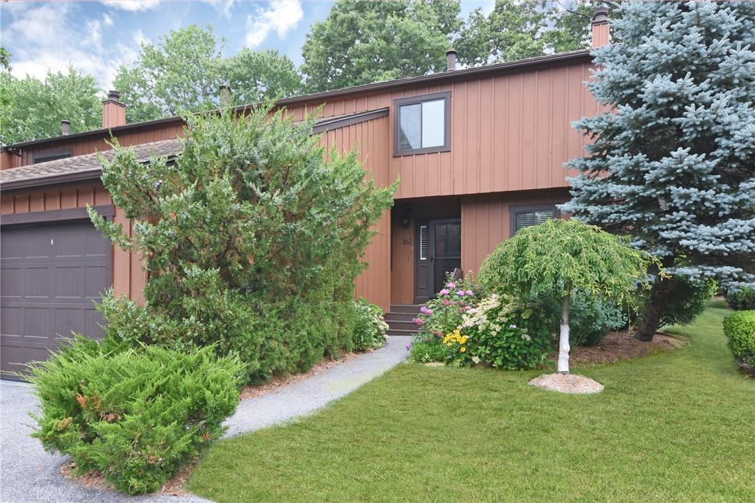 End unit featuring attached garage and a front yard