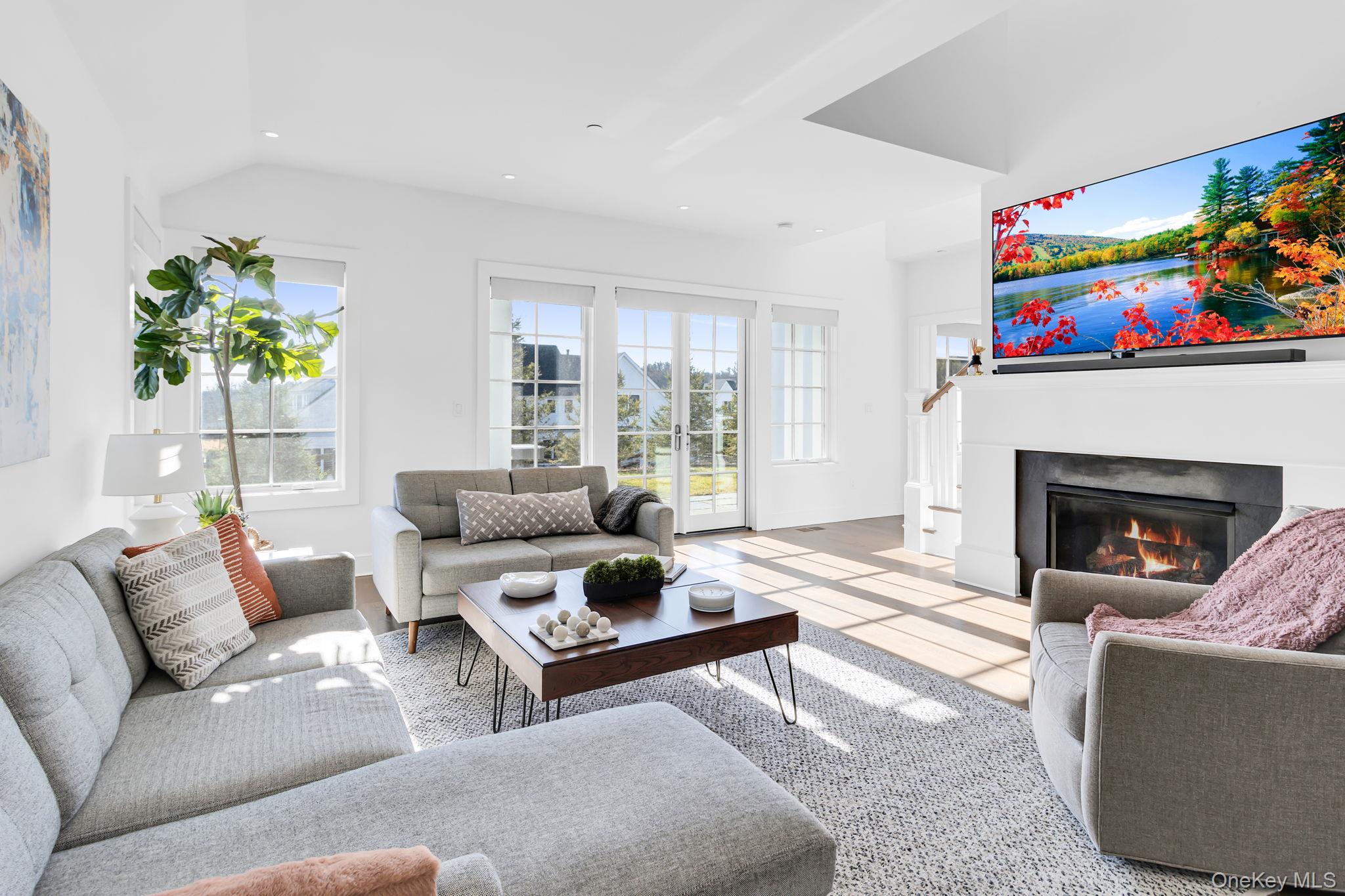 Living room featuring a wealth of natural light, light tile patterned floors, and lofted ceiling