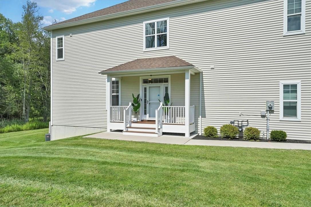 View of front of home with covered porch and a front lawn