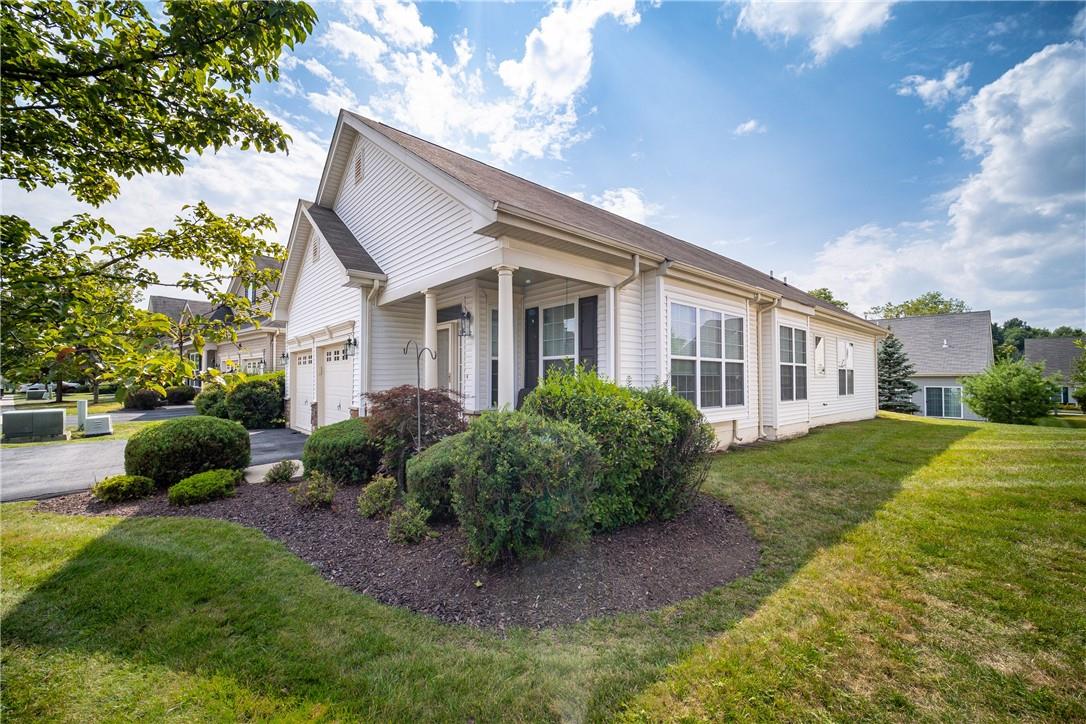 View of side of home featuring a garage and a lawn
