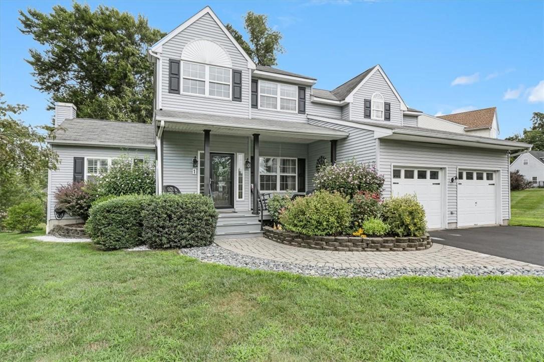 View of front of house with a garage, a front yard, and a porch