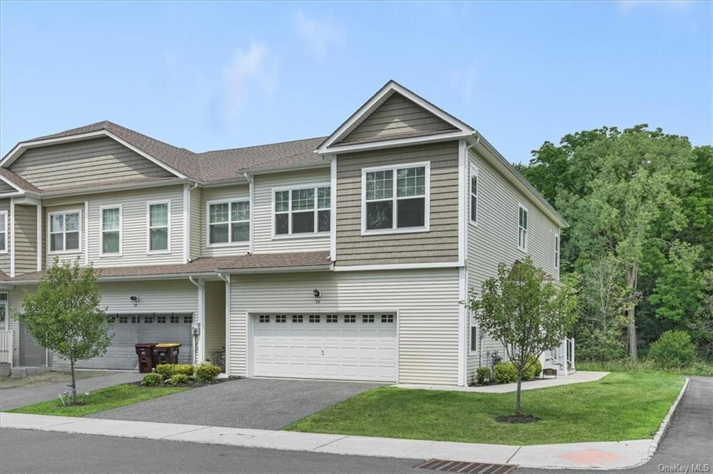 View of front of home with a garage and a front yard