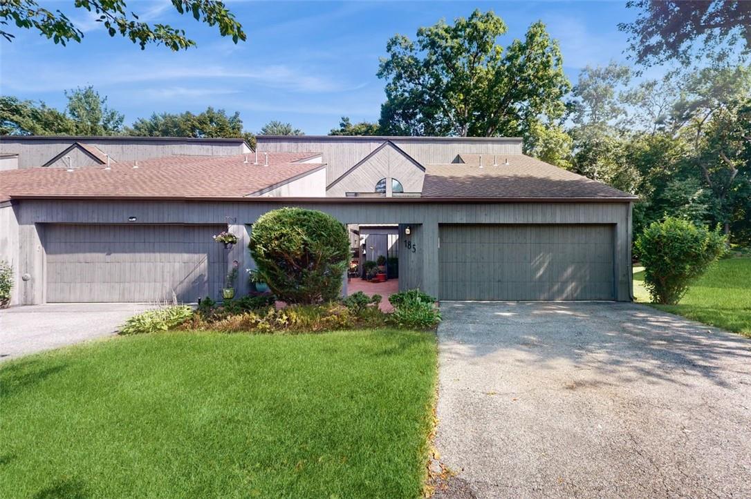 Townhouse featuring 2 car garage and a front yard