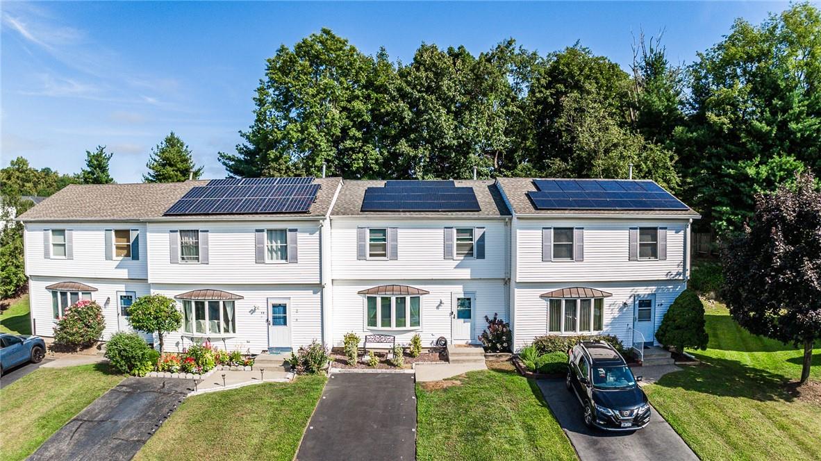 View of front of house featuring a front lawn and solar panels