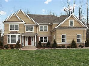 Stately brick and shingle, elegant Colonial on approximately a half acre of park-like property, featuring a three-car garage, paver driveway and walkway leading to front entrance.