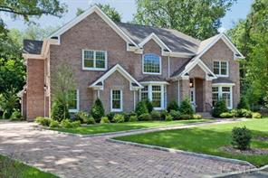 Stately all brick, elegant Colonial on approximately a half acre of park-like property, featuring a three-car garage, paver driveway and walkway leading to front entrance.