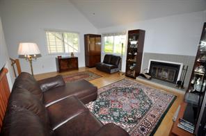 Large living room with cathedral ceiling, working fireplace, sky light and new hardwood floors.