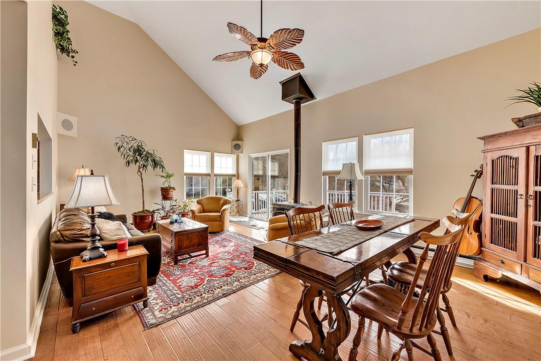 living room with wood burning stove, large dining area and sliders to the deck