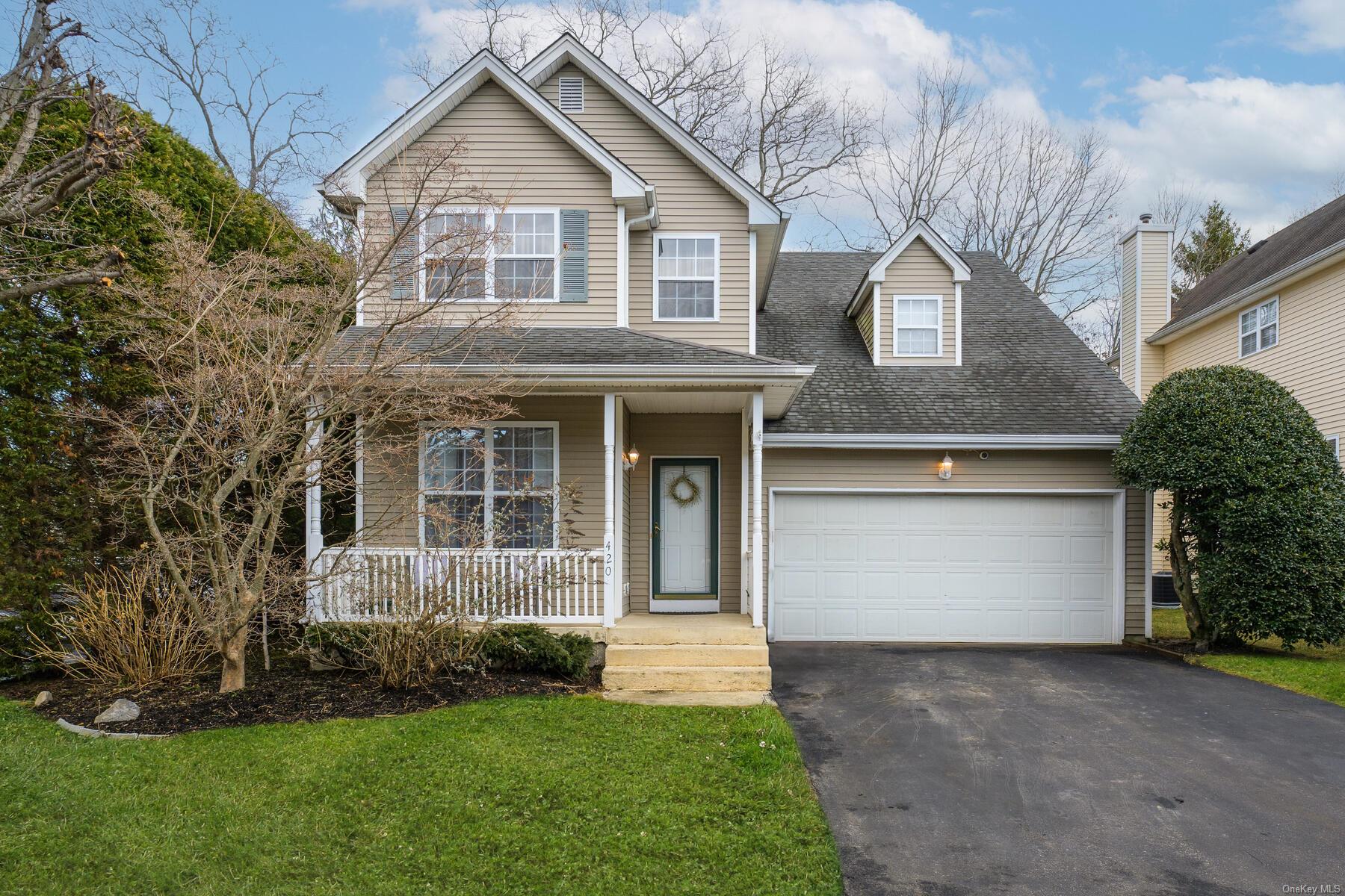 Front facade with a garage, covered porch, and a front yard