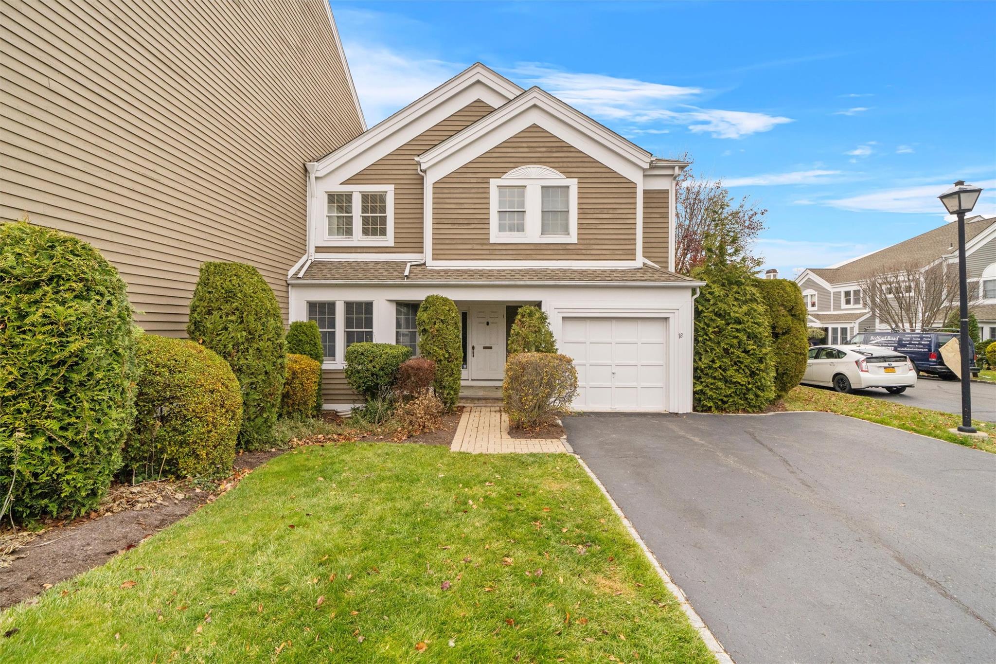 View of front of property with a garage and a front lawn