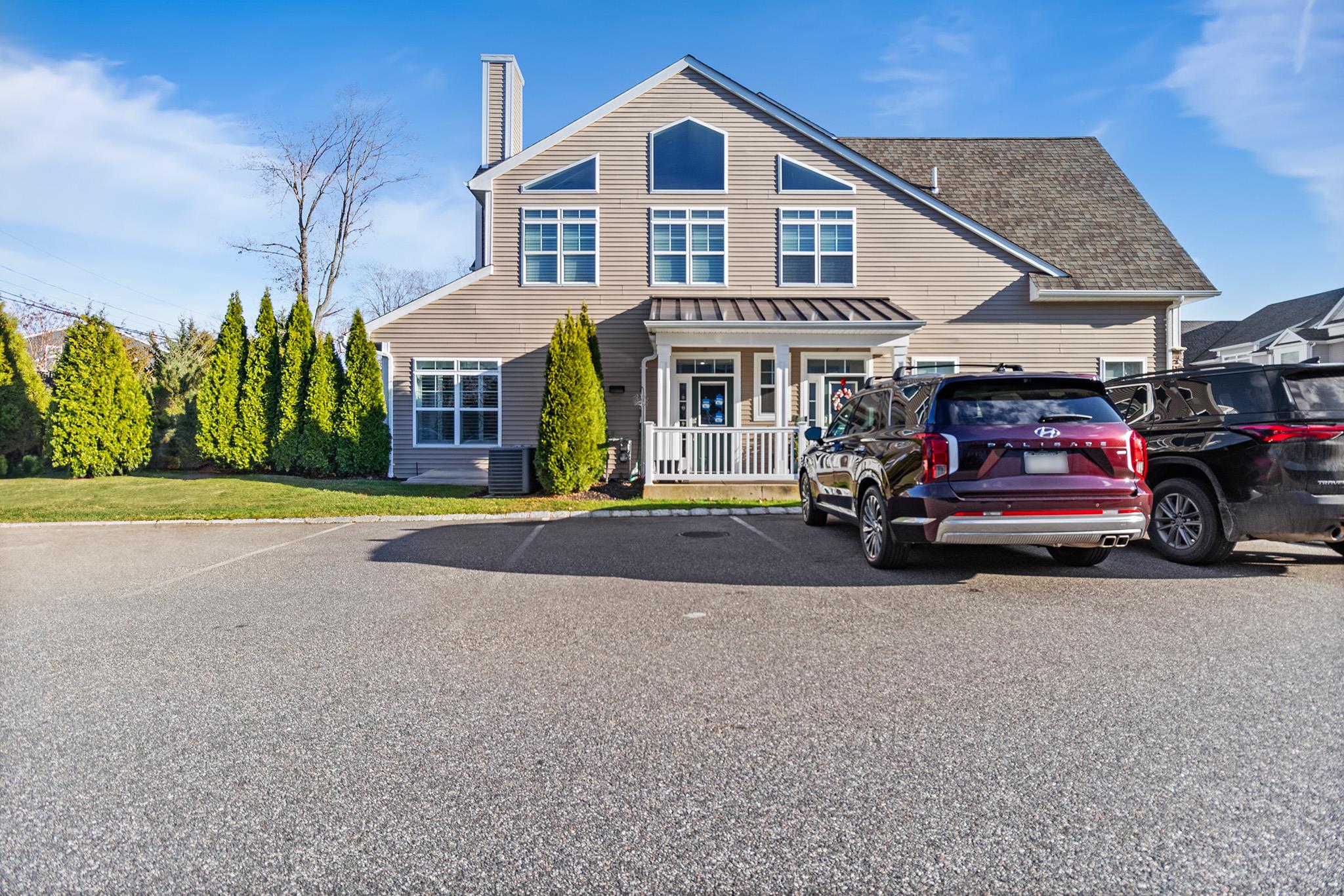 View of front of property with a front lawn, covered porch, and central AC unit