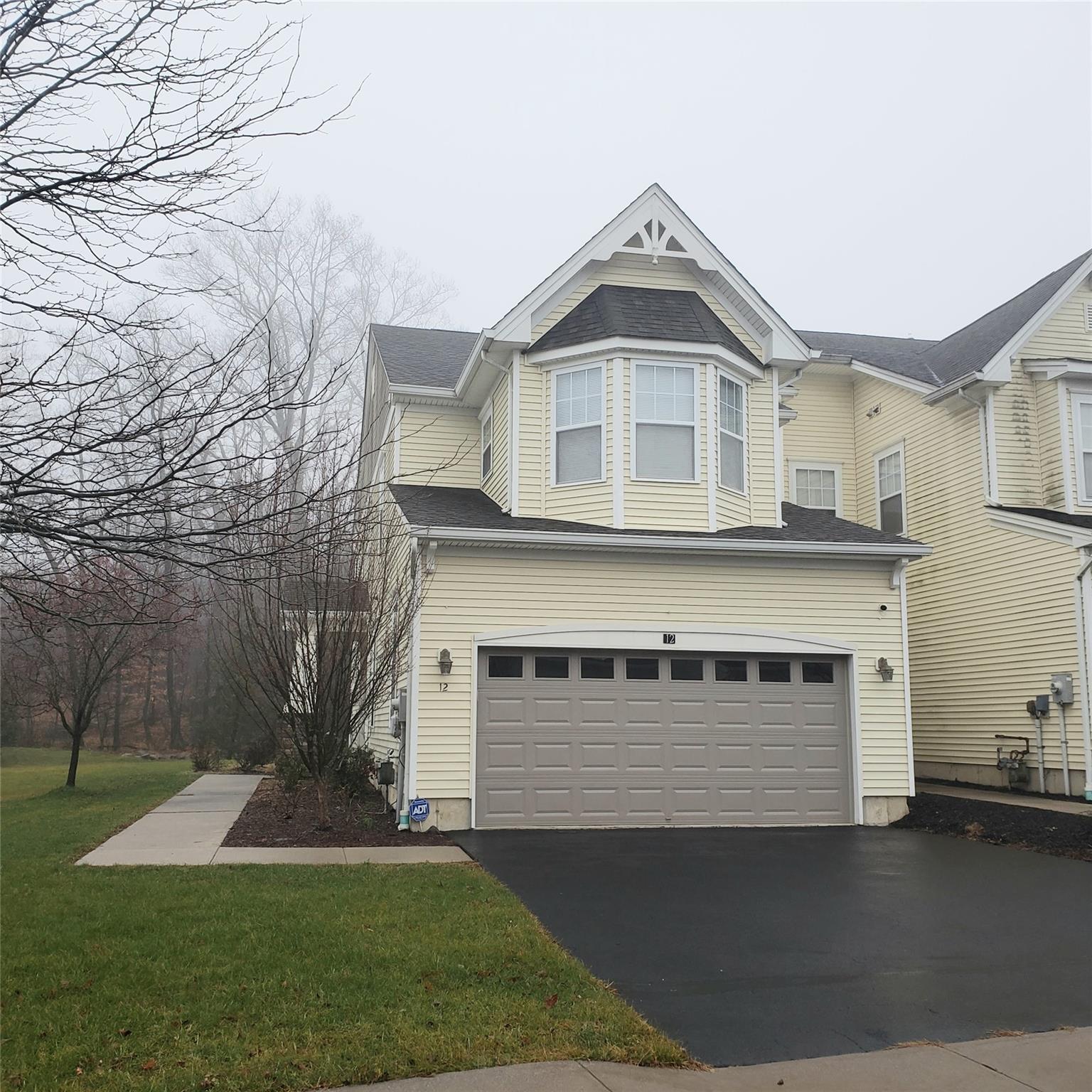 View of front of house with a front lawn and a garage