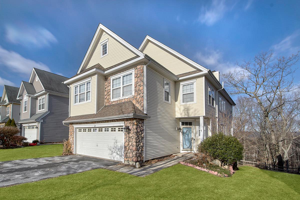 View of front of property featuring a garage and a front lawn