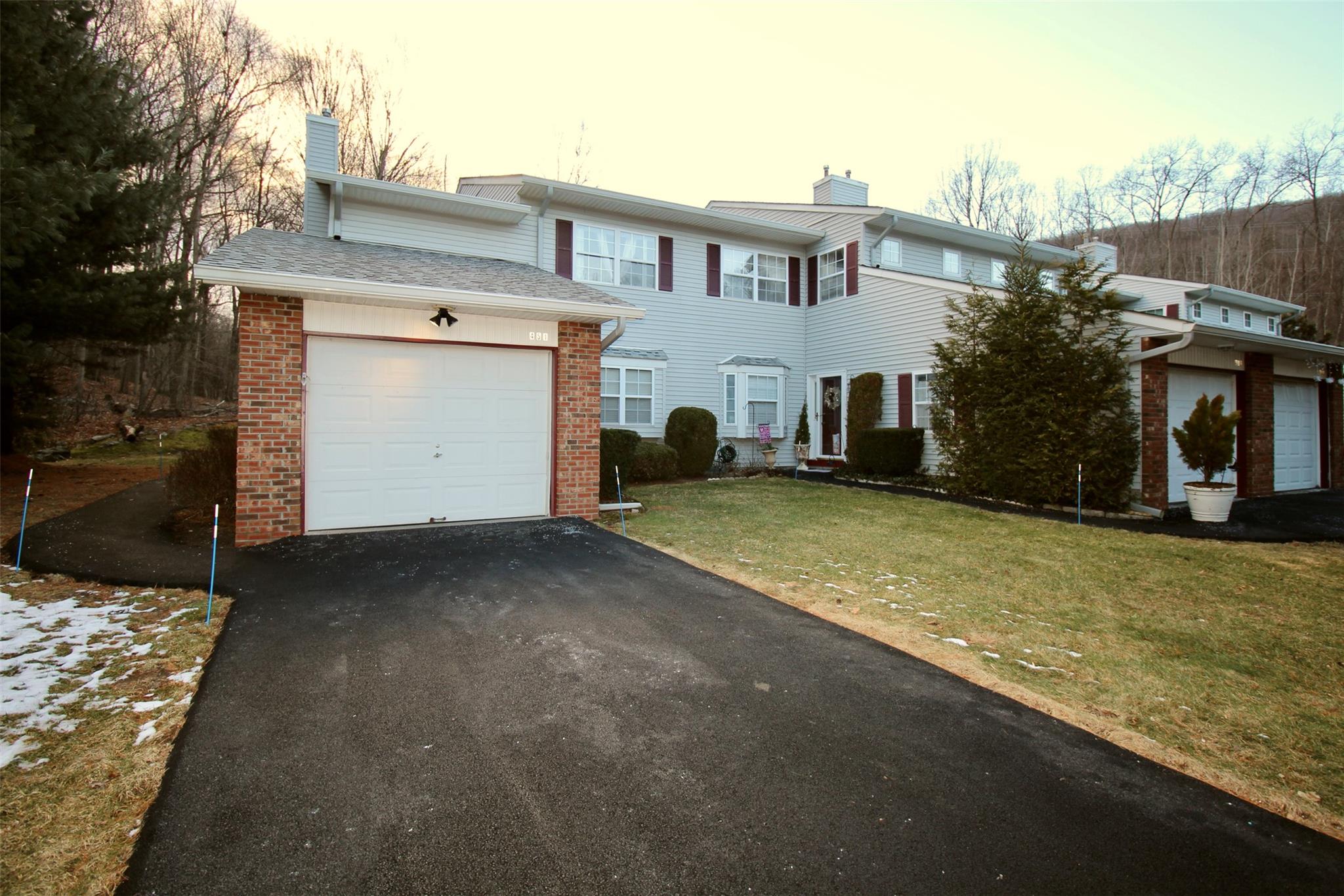 View of front of home with a garage and a lawn