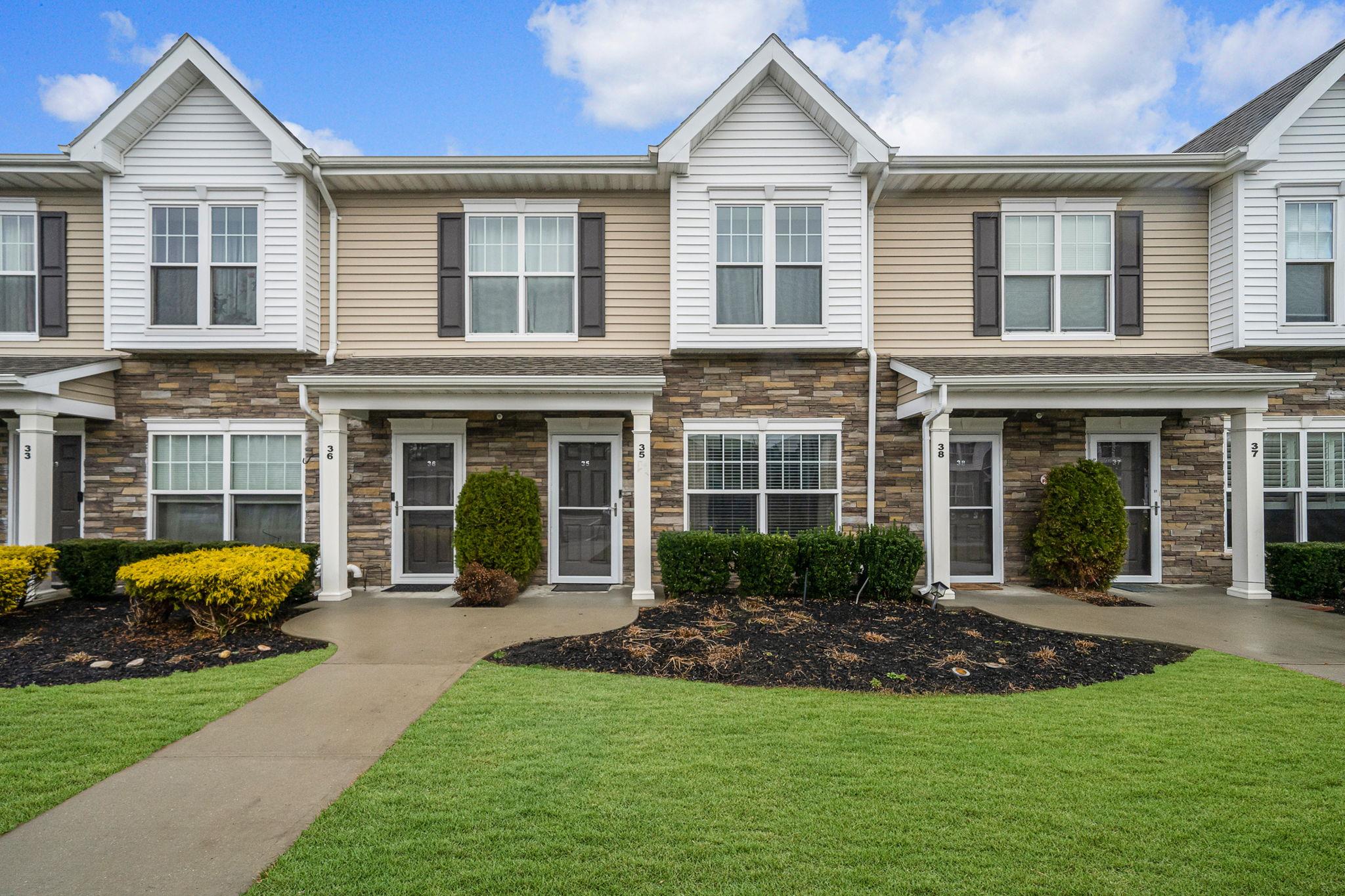 Townhome / multi-family property with a front lawn