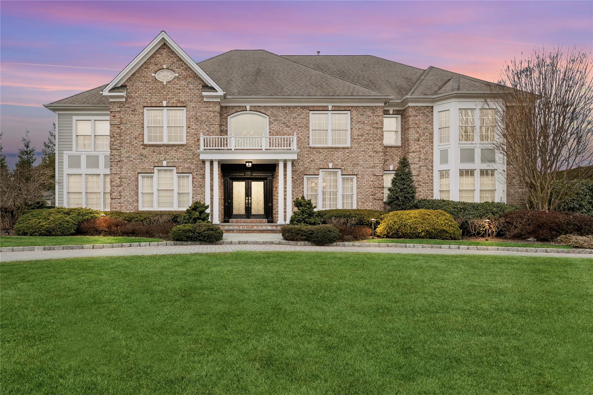 View of front of home with french doors, a balcony, and a yard