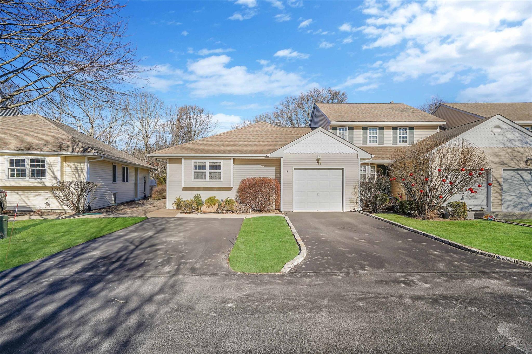 View of front of property with a garage and a front lawn