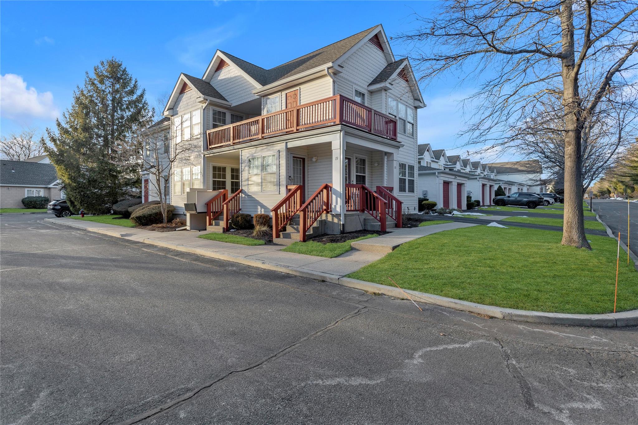 View of front of home with a balcony and a front yard
