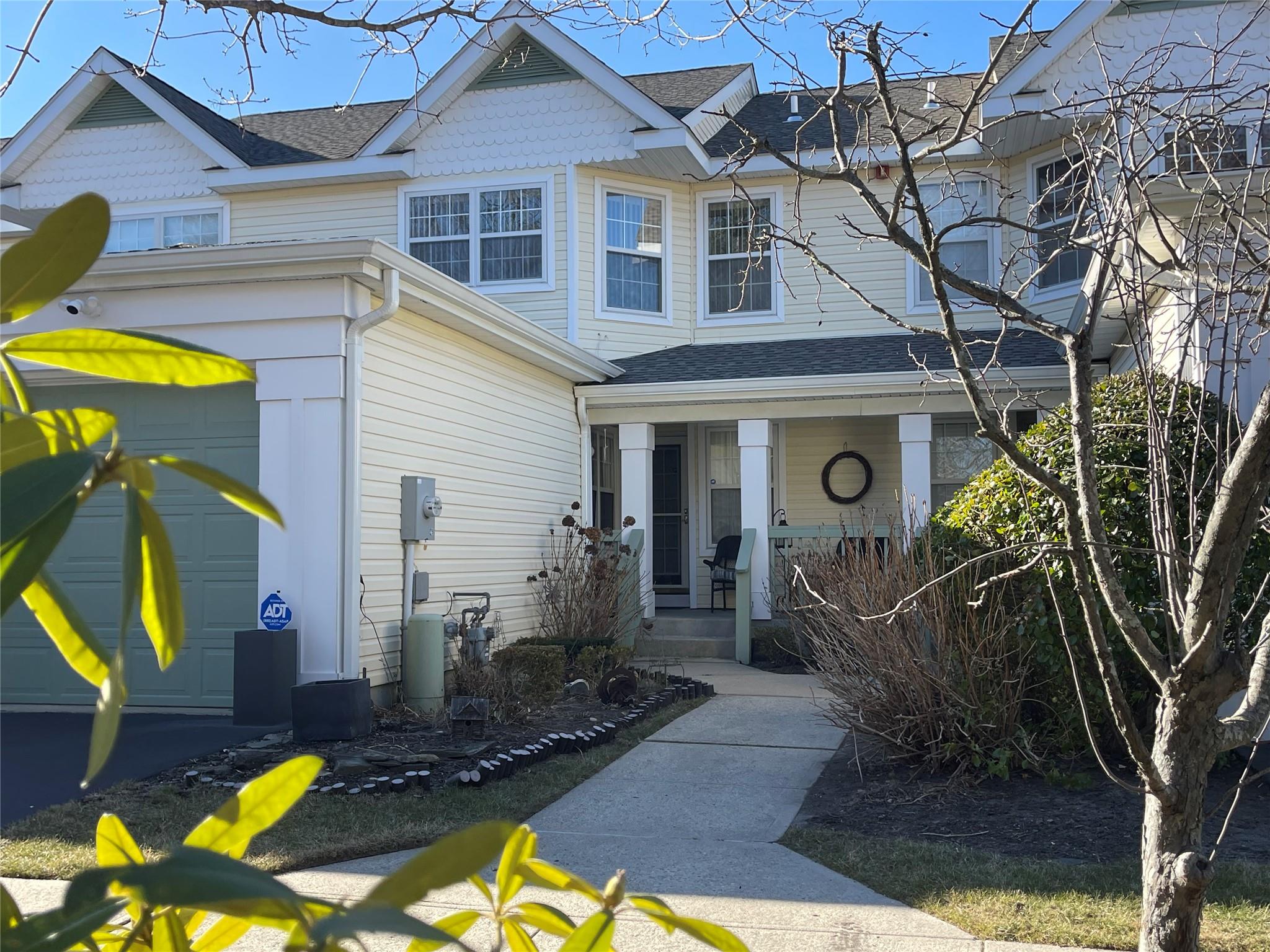 View of front of property featuring covered porch and a garage