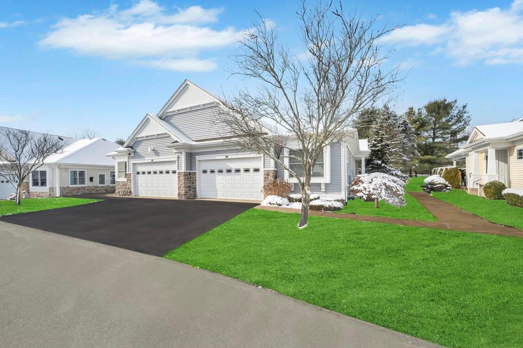 View of front facade featuring a garage and a front lawn