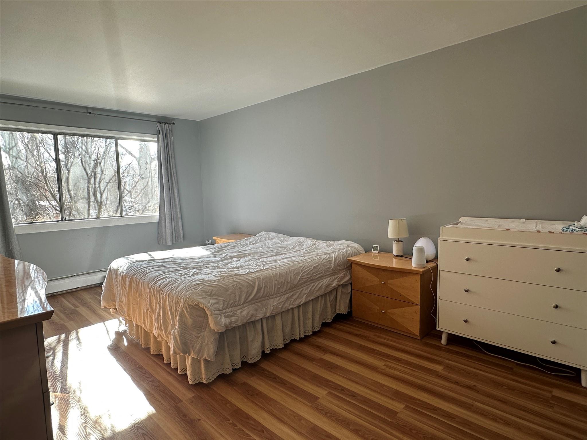 Bedroom with hardwood / wood-style flooring and a baseboard radiator