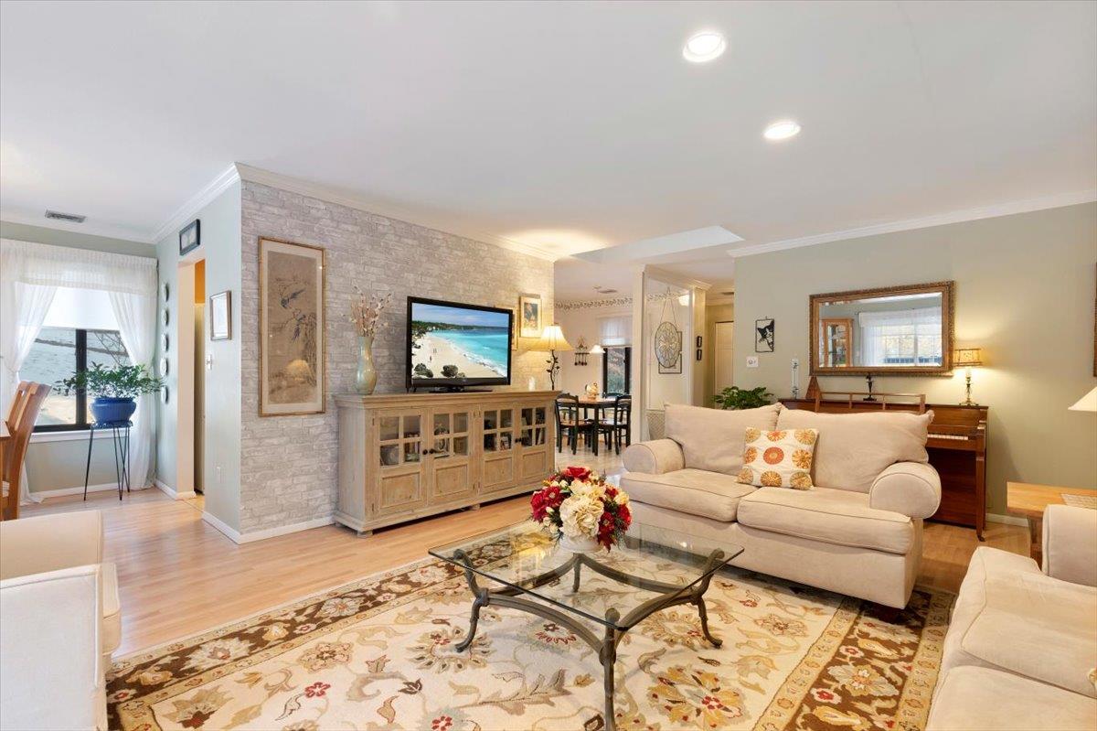 Living room with crown molding and light wood-style flooring
