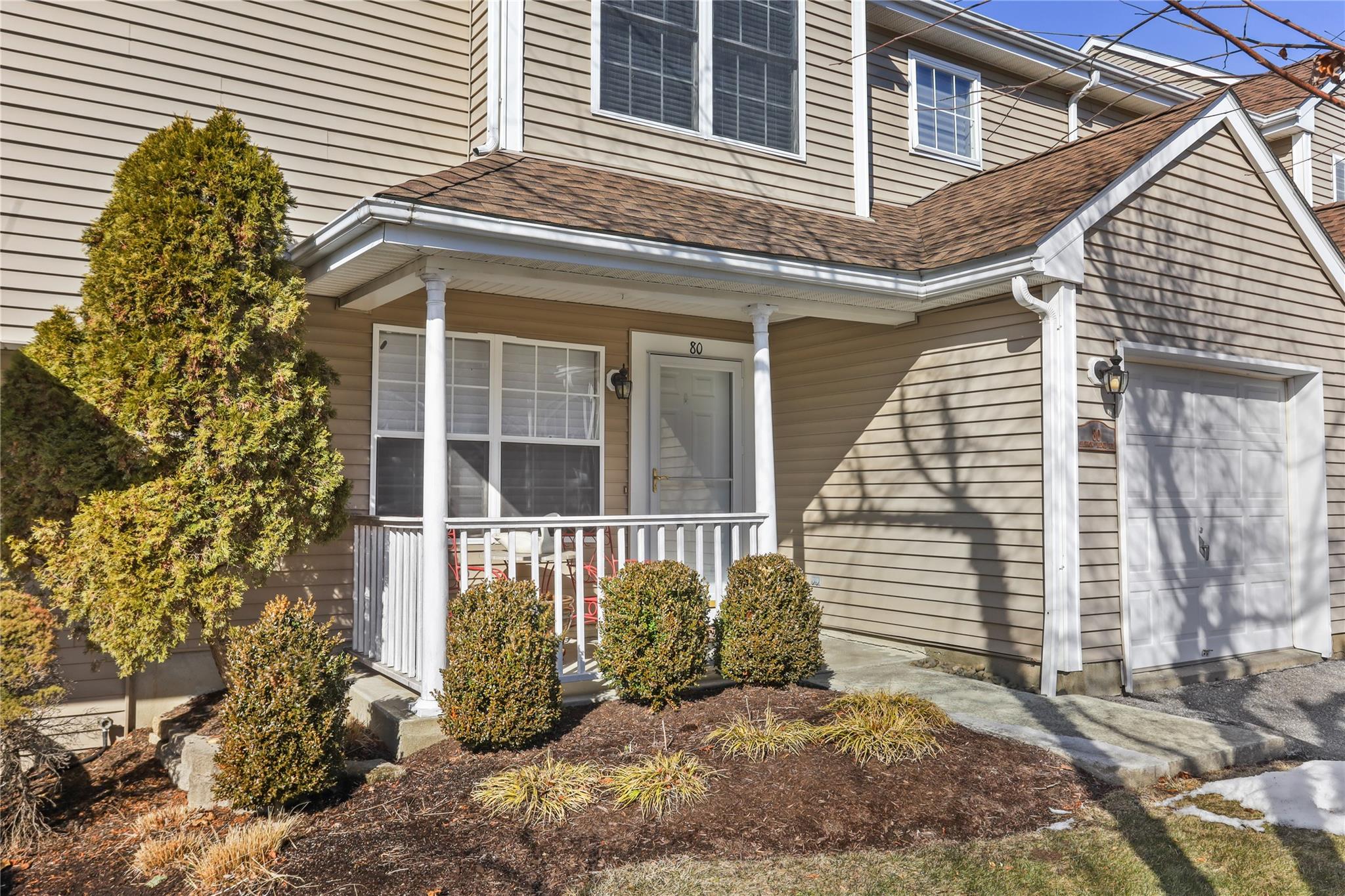 View of home's exterior featuring a porch and a garage