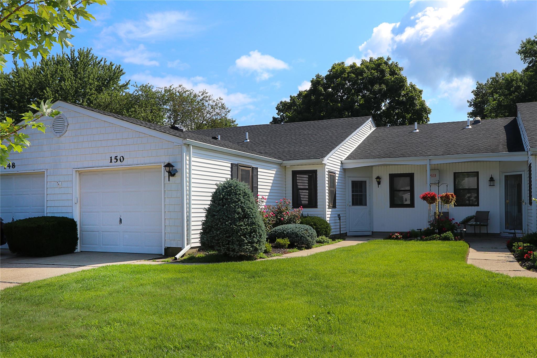 Ranch-style house featuring a garage and a front yard