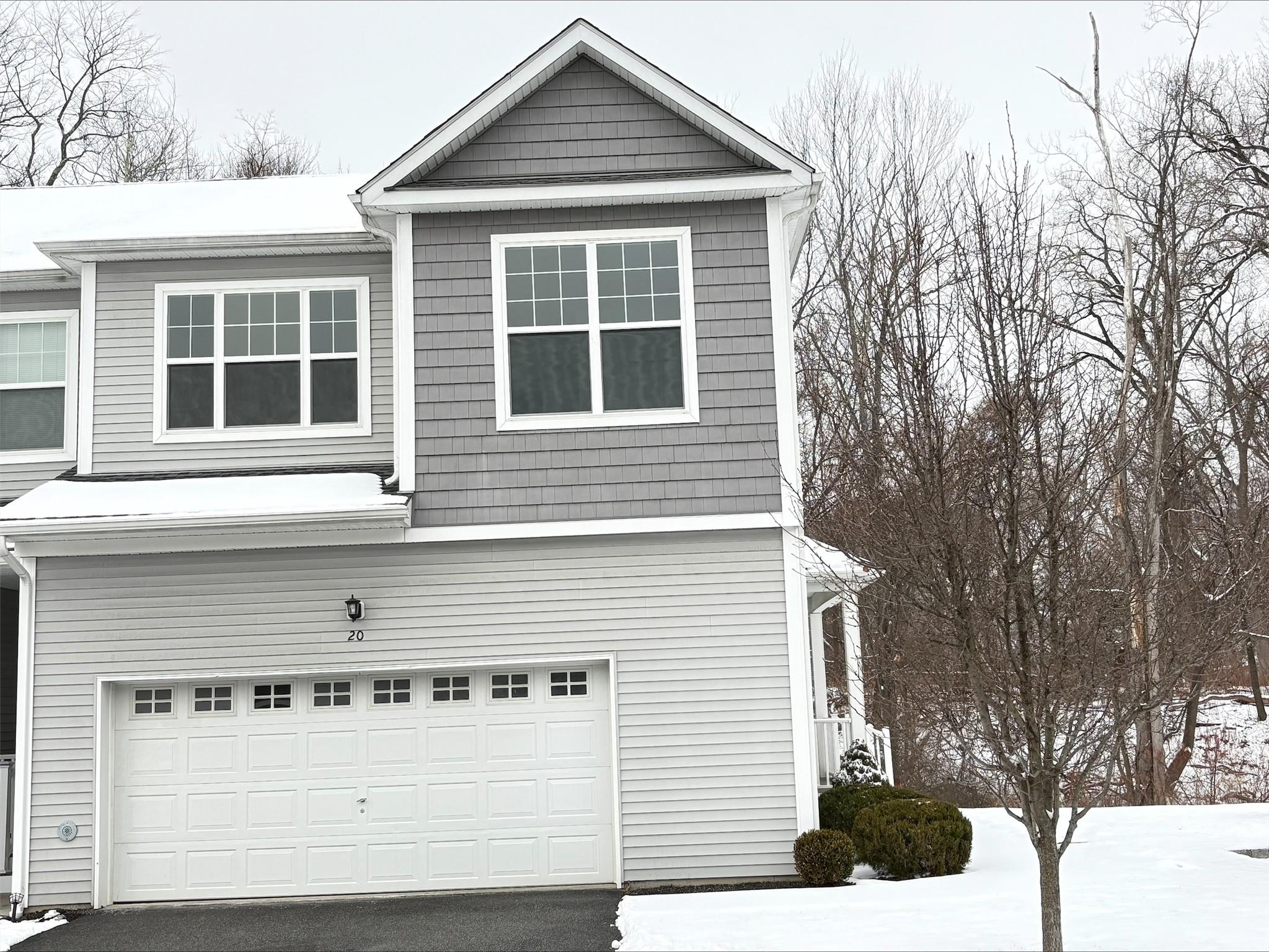 View of snow covered exterior with a garage