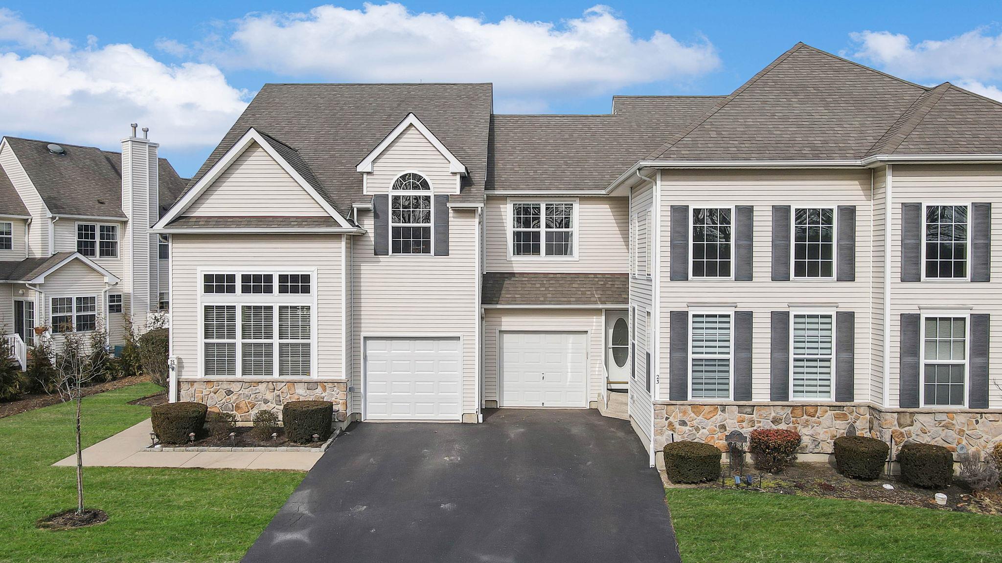 View of front of property with a garage and a front lawn