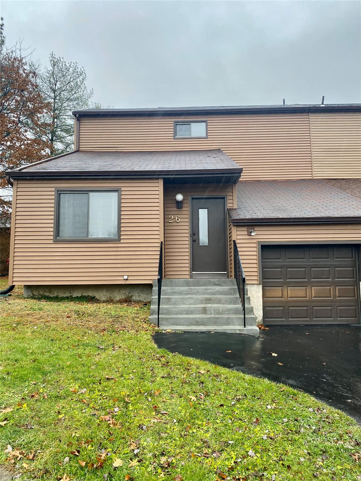 View of front of property featuring a garage and a front lawn