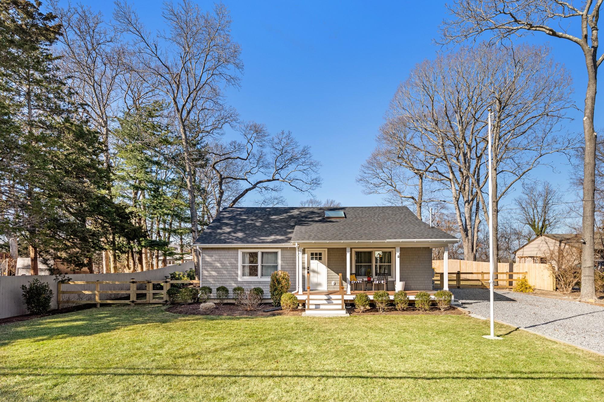 View of front facade with covered porch and a front lawn