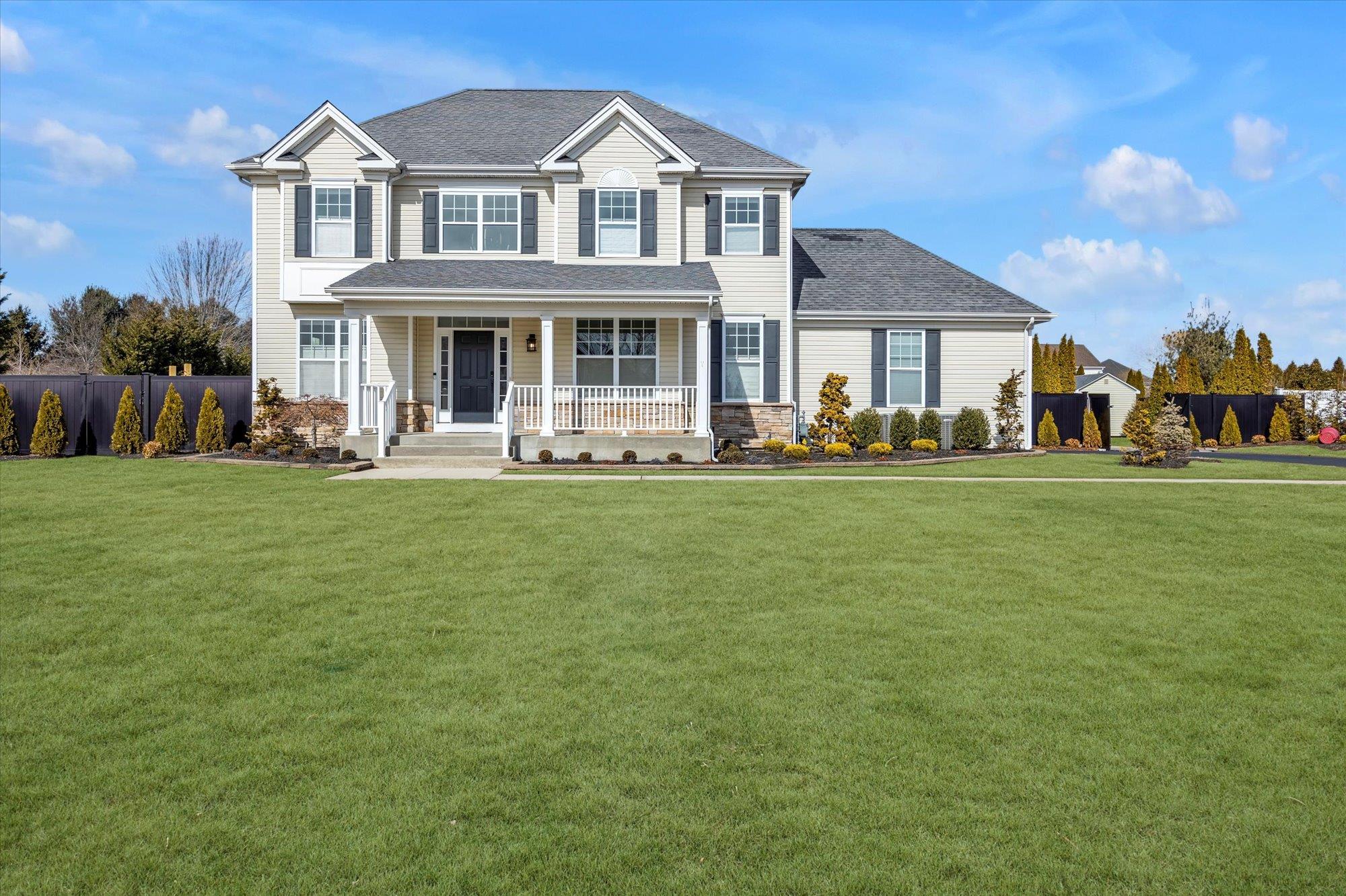 View of front facade with covered porch and a front lawn
