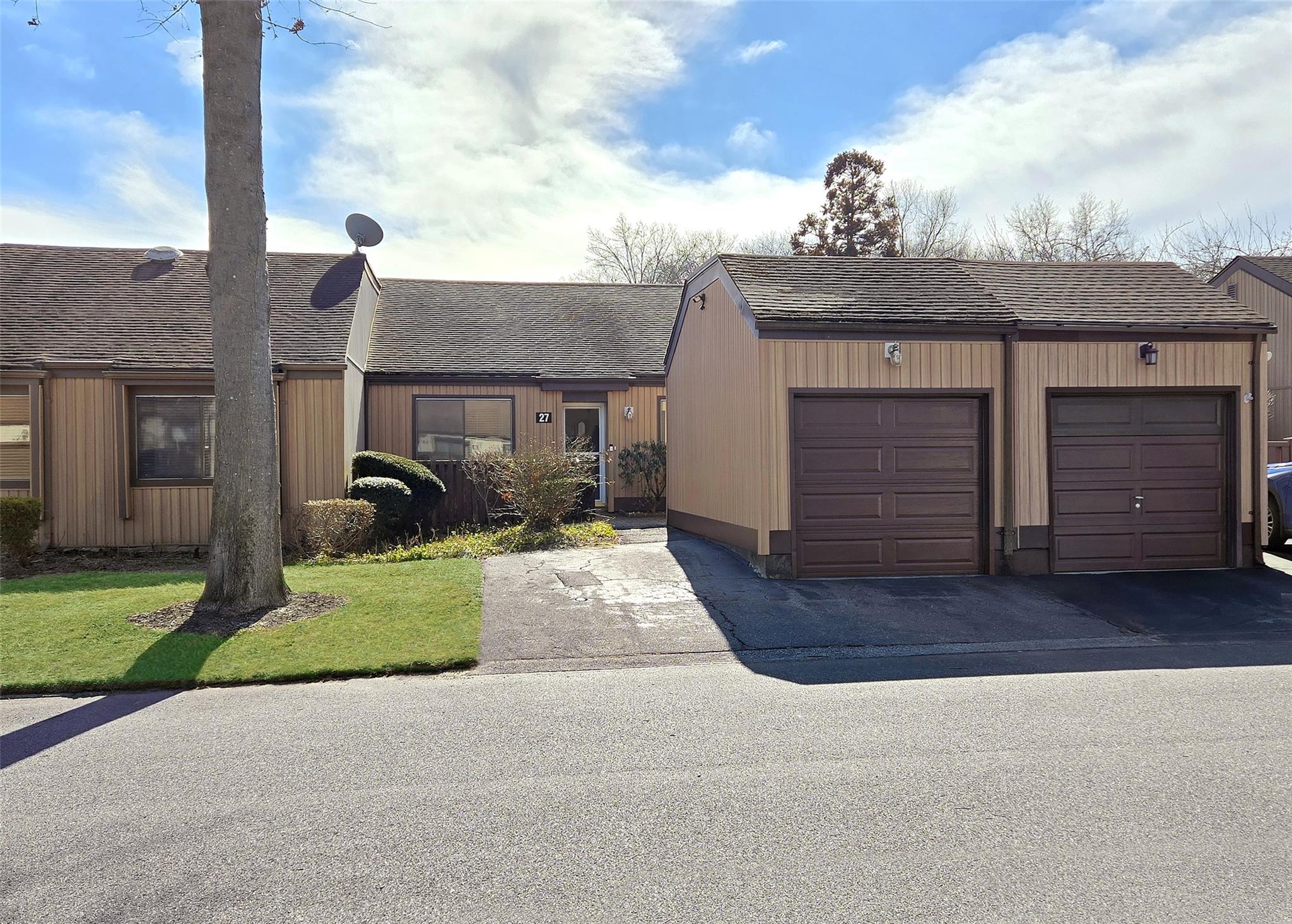 Front of unit featuring a garage and a private driveway