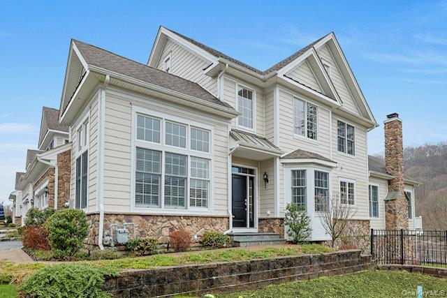View of front of property featuring fence and stone siding