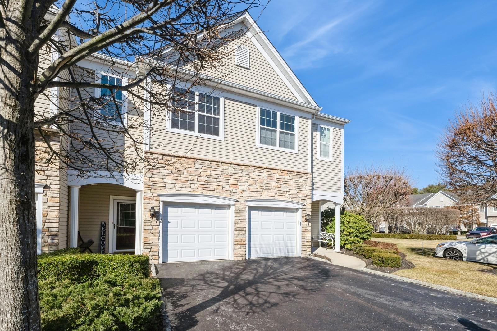View of front of property featuring a garage and aphalt driveway
