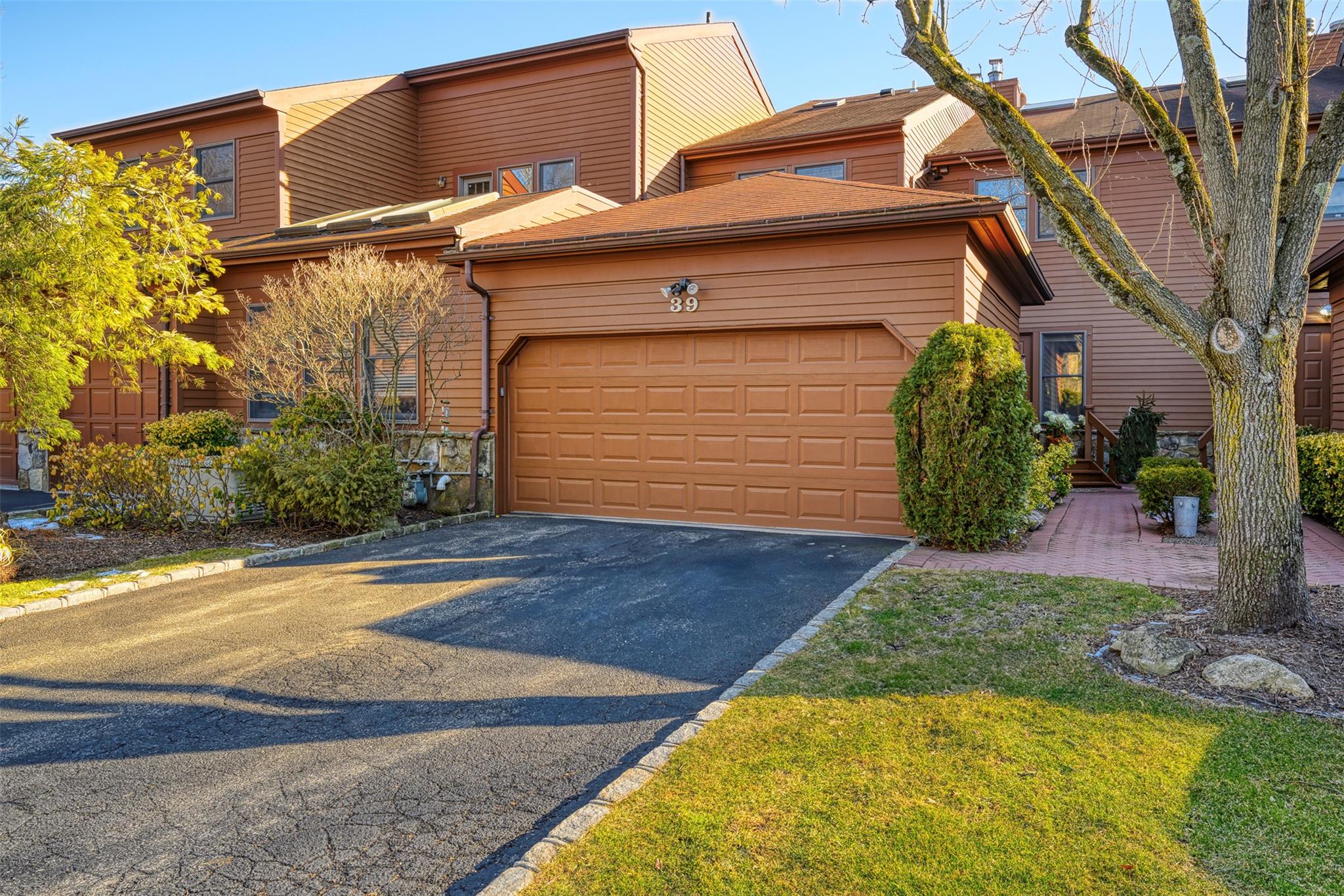 View of front of property featuring a garage and aphalt driveway
