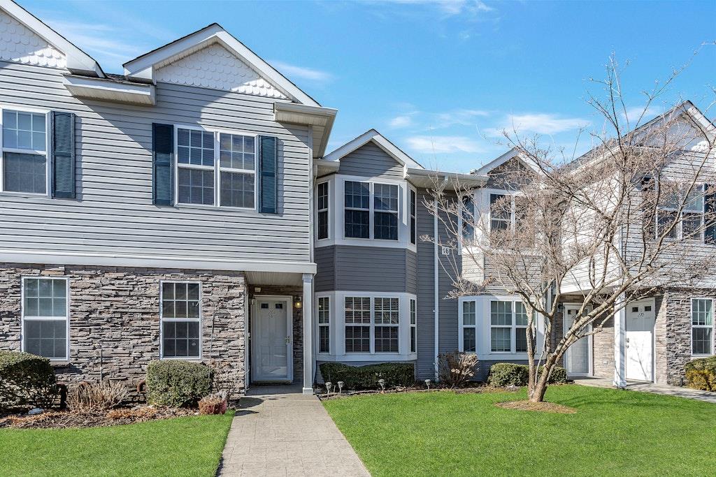 View of front of home featuring stone siding and a front lawn