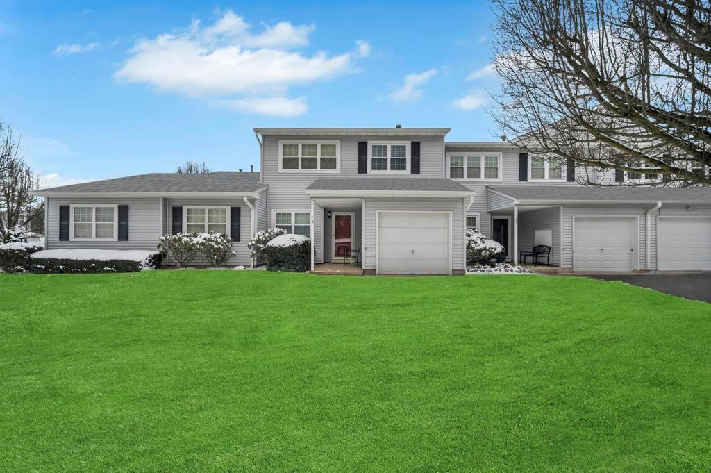View of front of home featuring a front yard, driveway, and an attached garage