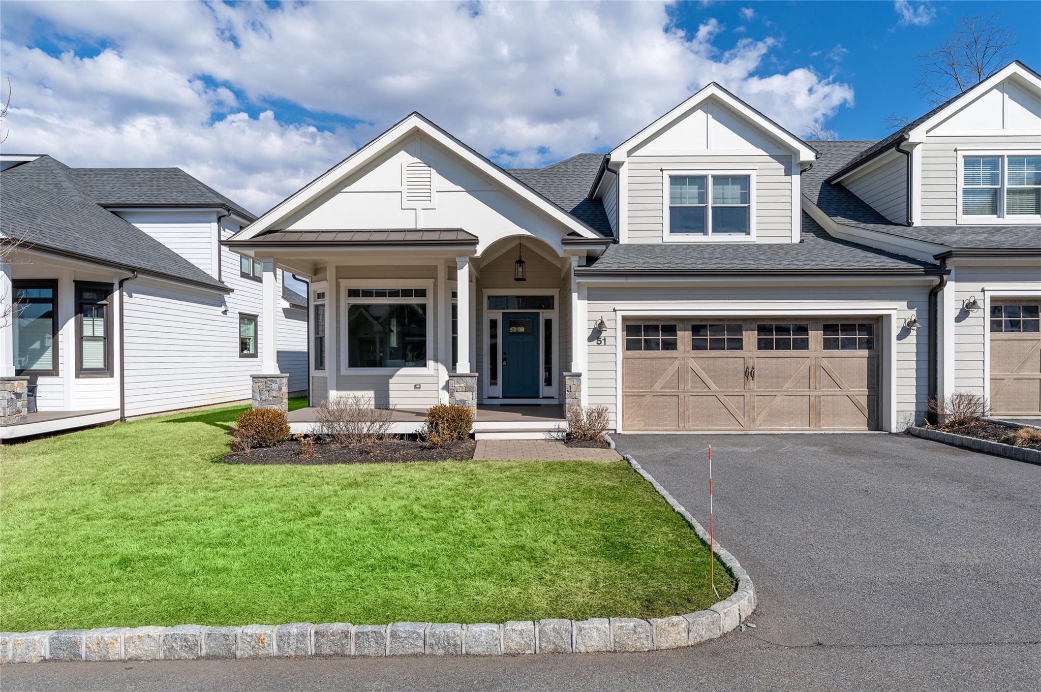 View of front facade with aphalt driveway, a front yard, roof with shingles, and an attached garage