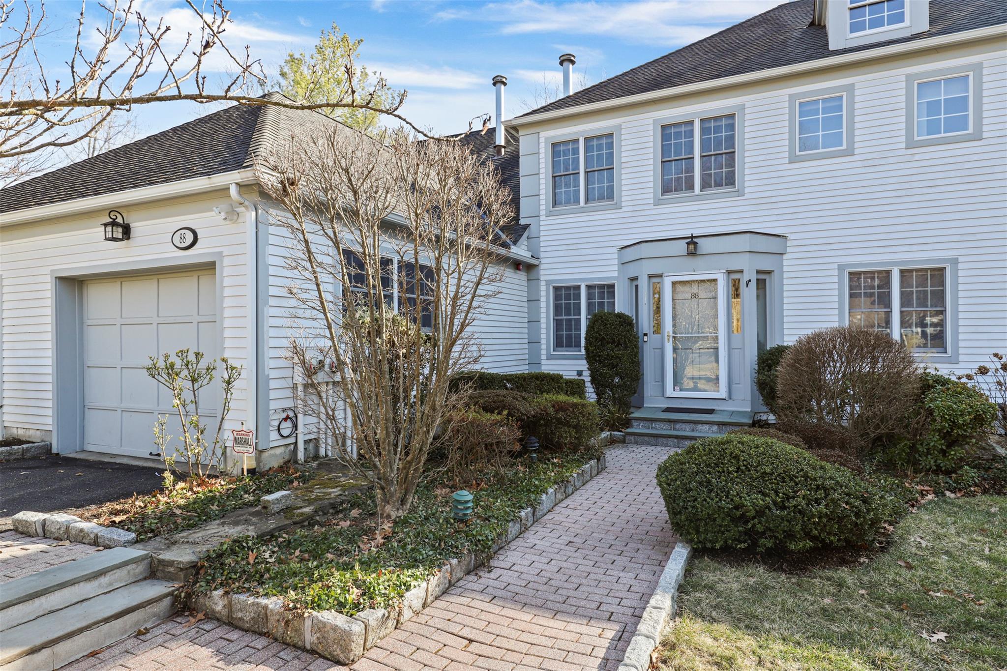 View of front with a garage and a shingled roof