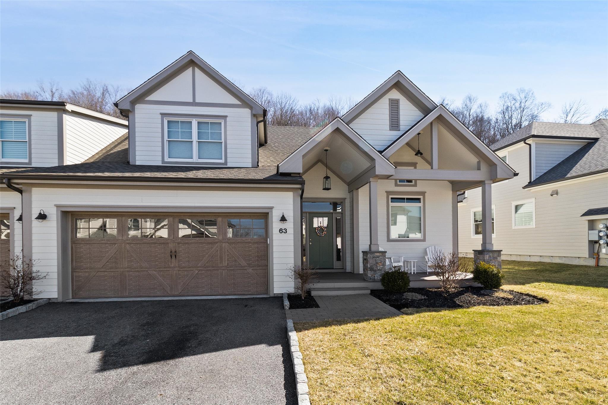 View of front of home featuring a garage, driveway and front lawn